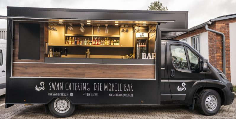 Bar truck Schwarzer Getränketruck mit Holzverkleidung und offenem Fenster.